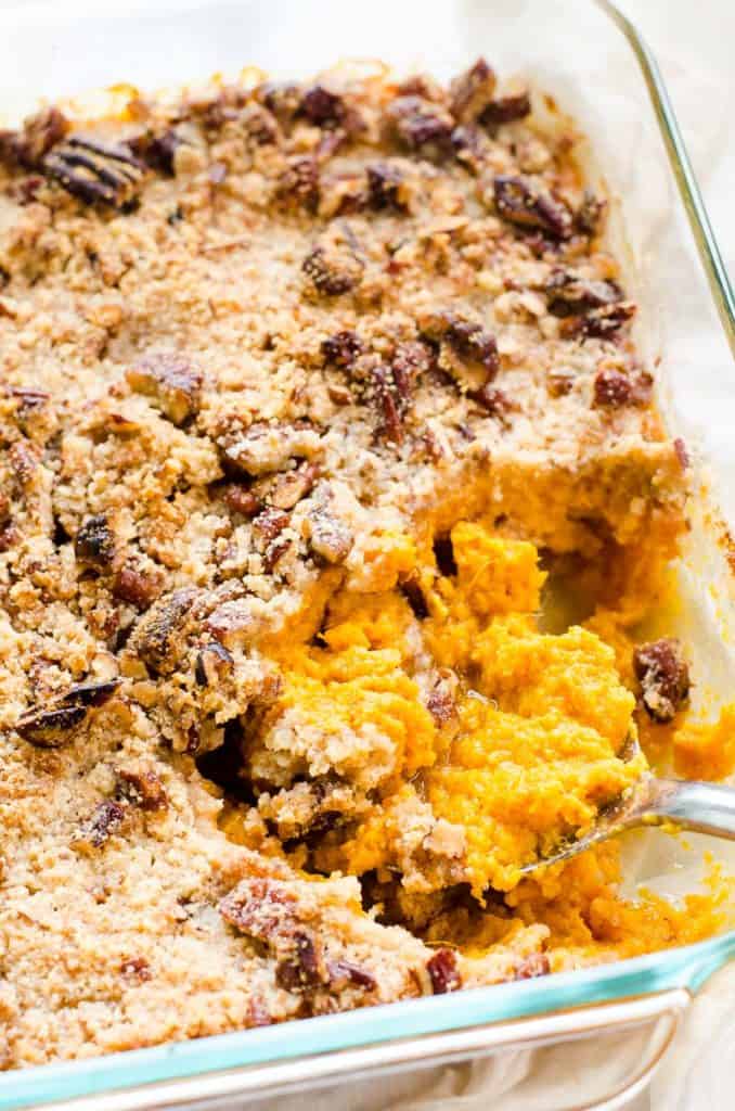 Healthy sweet potato casserole being dished out of baking pan.