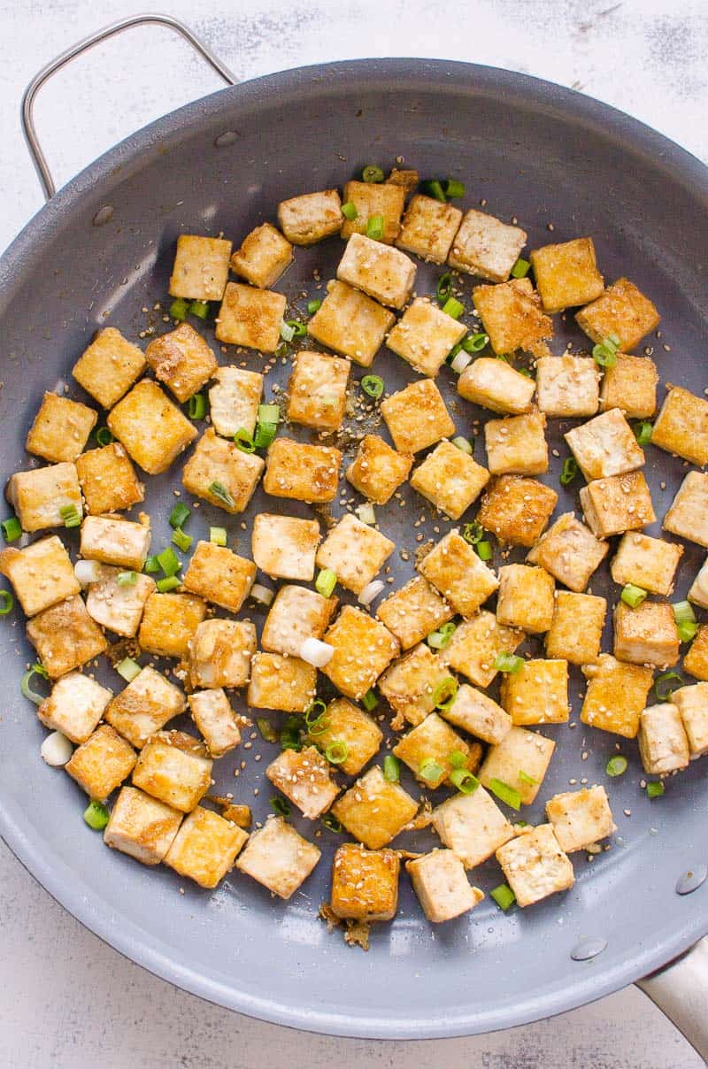 Crisy Fried Tofu on skillet garnished with green onions 