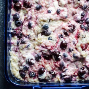 Brown rice pudding with cherries in blue baking dish.