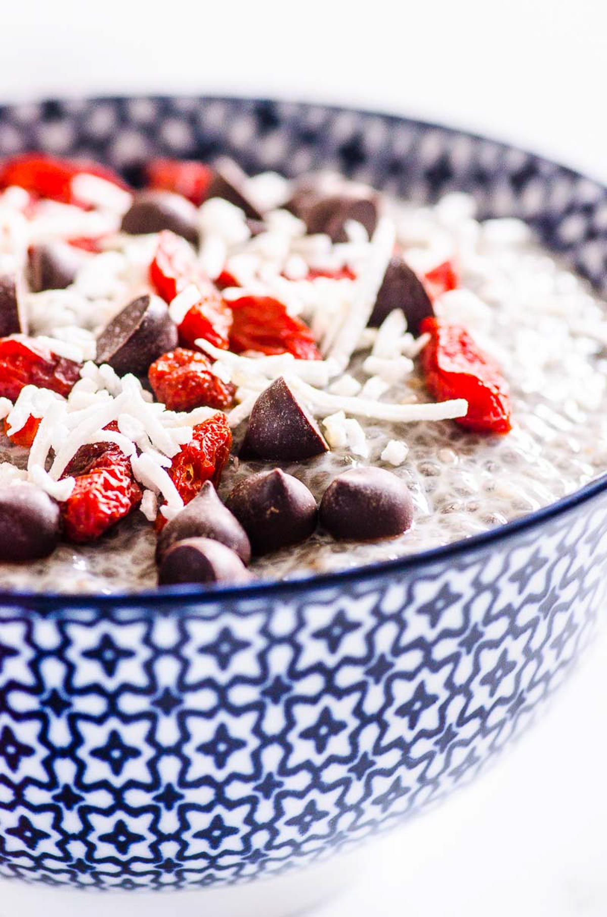 Vanilla chia pudding in blue and white bowl with toppings.