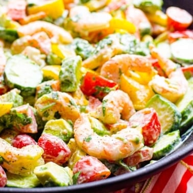 Closeup shrimp and avocado salad with tomatoes, peppers and creamy yogurt dressing.