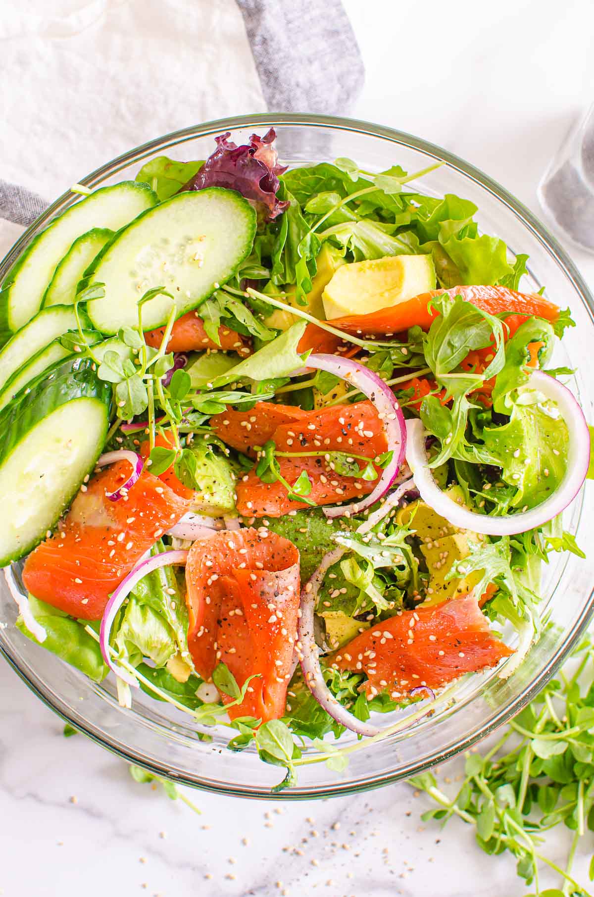 Smoked salmon salad in a bowl garnished with sesame seeds.