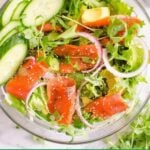Smoked salmon salad in a bowl with cucumber, avocado and red onion.