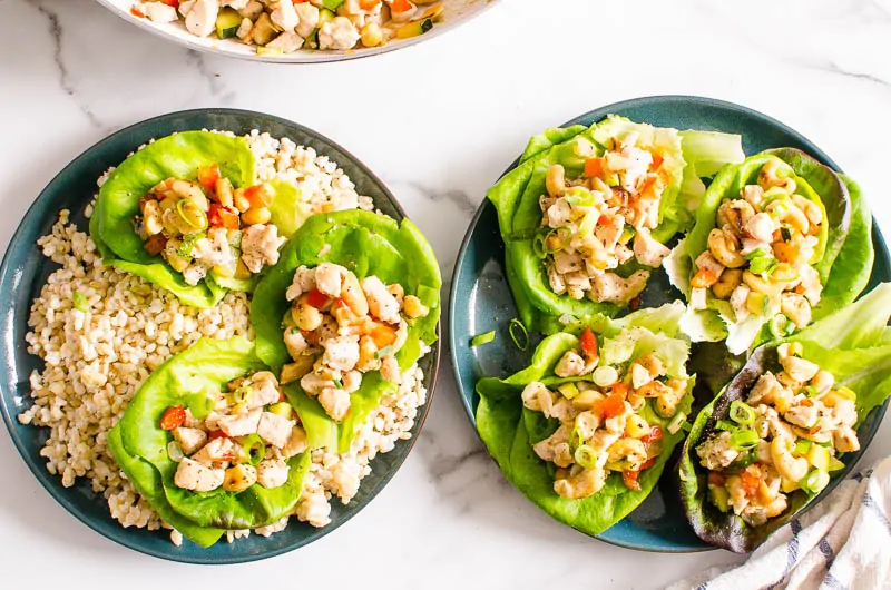chicken lettuce wraps served on plates over rice