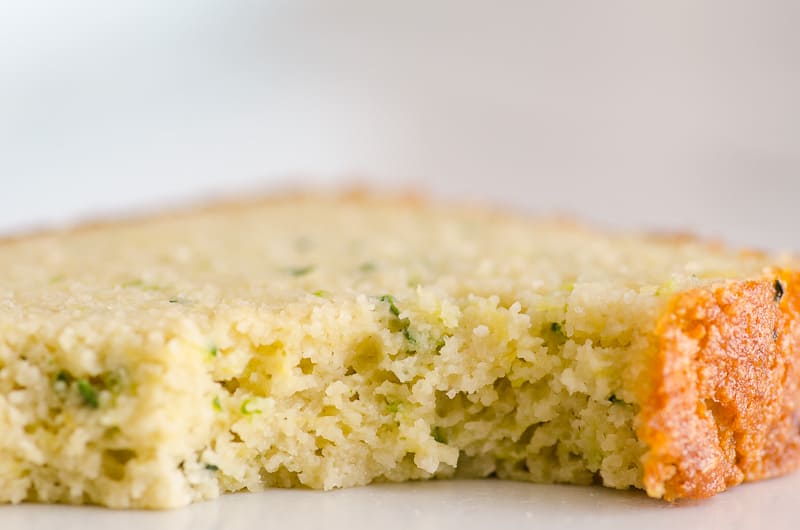 Healthy lemon zucchini bread slice bite taken out of and texture shown.