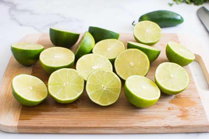 Sliced in halves limes on a cutting board.