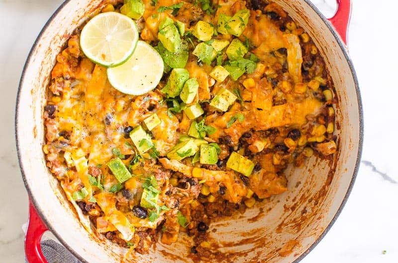 enchilada skillet with avocado and sliced lime for garnish