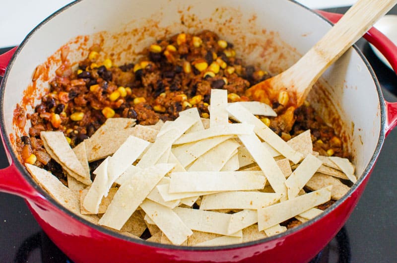 adding tortillas and ingredients for beef southwest skillet