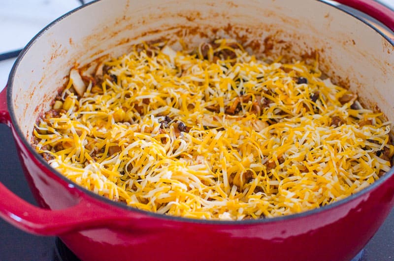 adding cheese for mexican skillet dinner