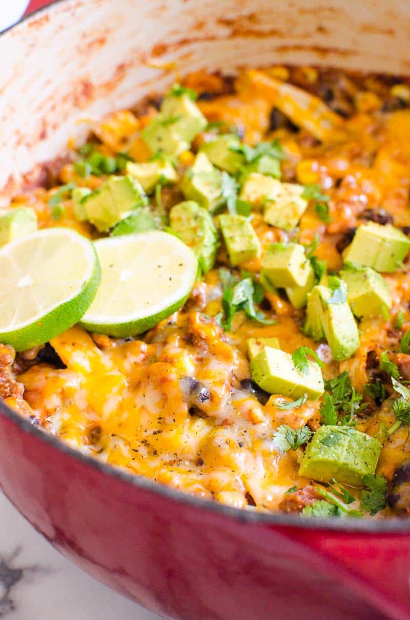 stovetop enchiladas topped with cheese avocado and lime slices