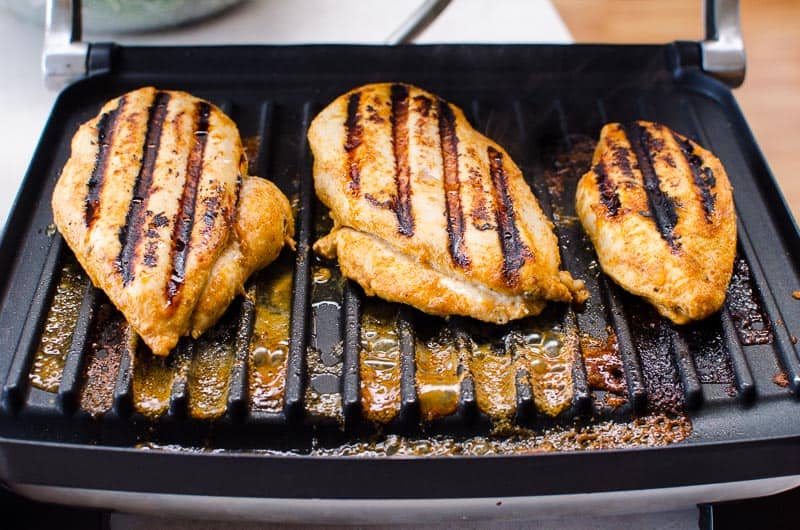 Three chili lime chicken breasts on a grill.