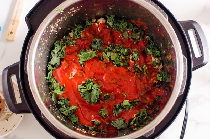 Sauce and spinach in Instant Pot.