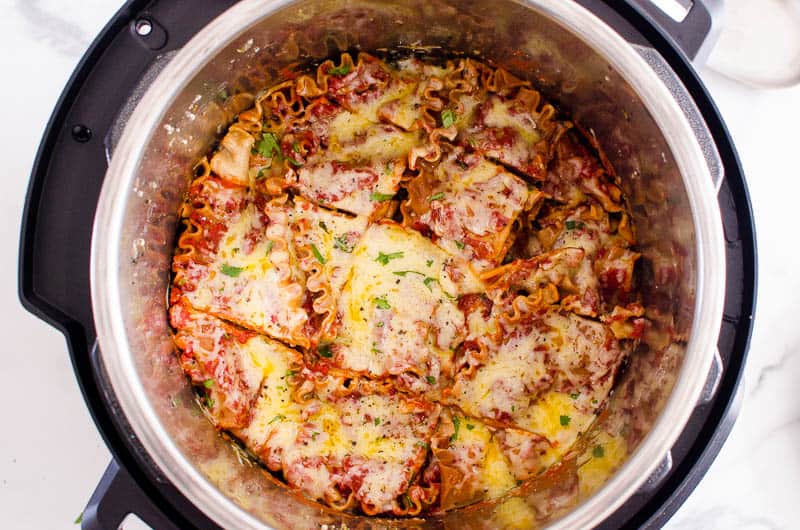 Instant Pot lasagna cut into square in pressure cooker pot.