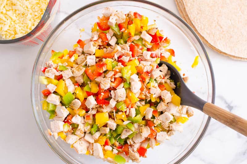 Diced bell peppers and chicken in a bowl.