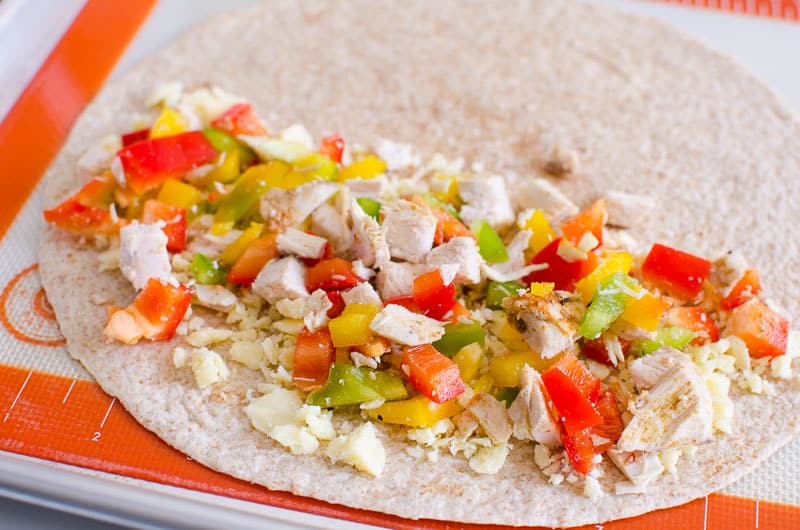 Chicken, bell peppers and cheese on half a tortilla.