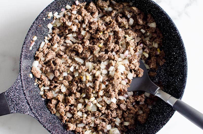 Ground beef and onion in skillet.