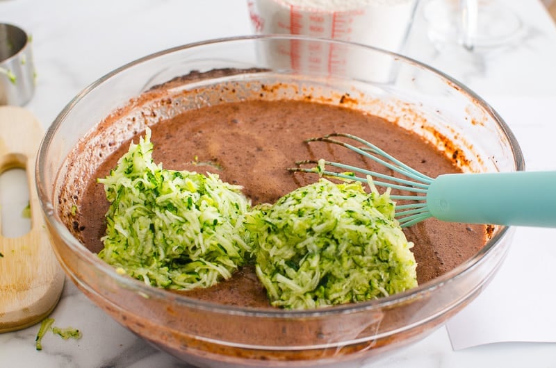 grated zucchini inside the bowl with a whisk and batter
