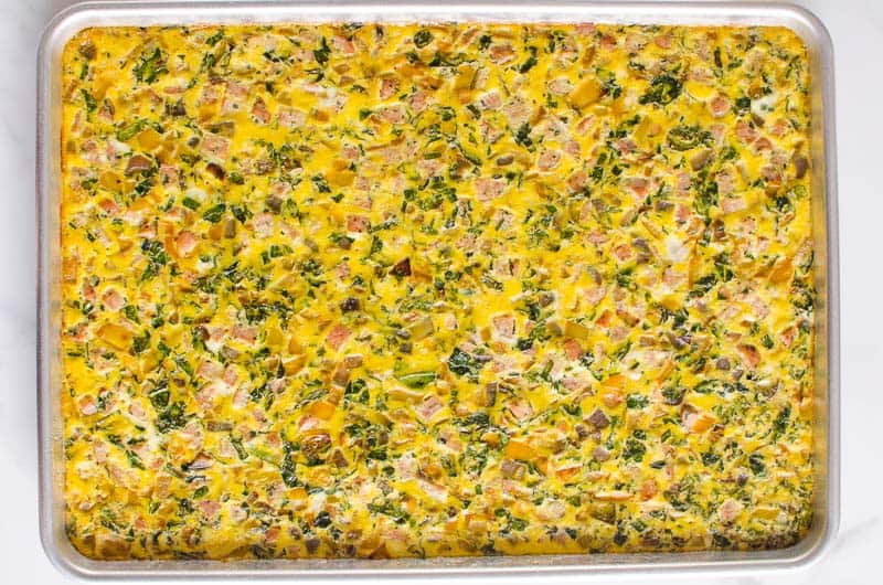 Eggs baked with sausage and veggies in baking sheet.