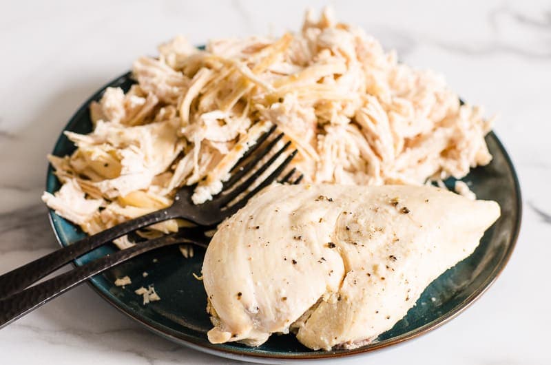 Instant Pot whole chicken breast and shredded chicken breast on a plate.