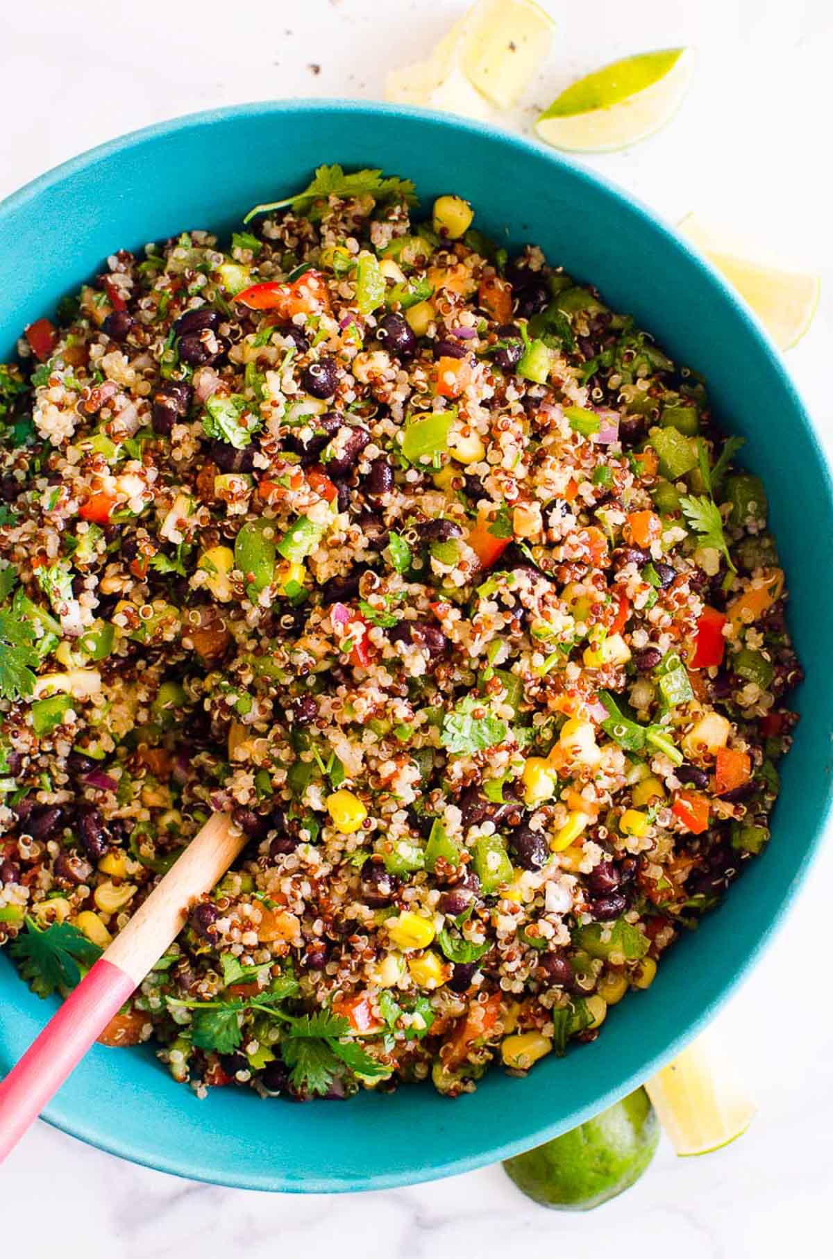 Southwest quinoa salad in a bowl with a spoon and fresh lime.