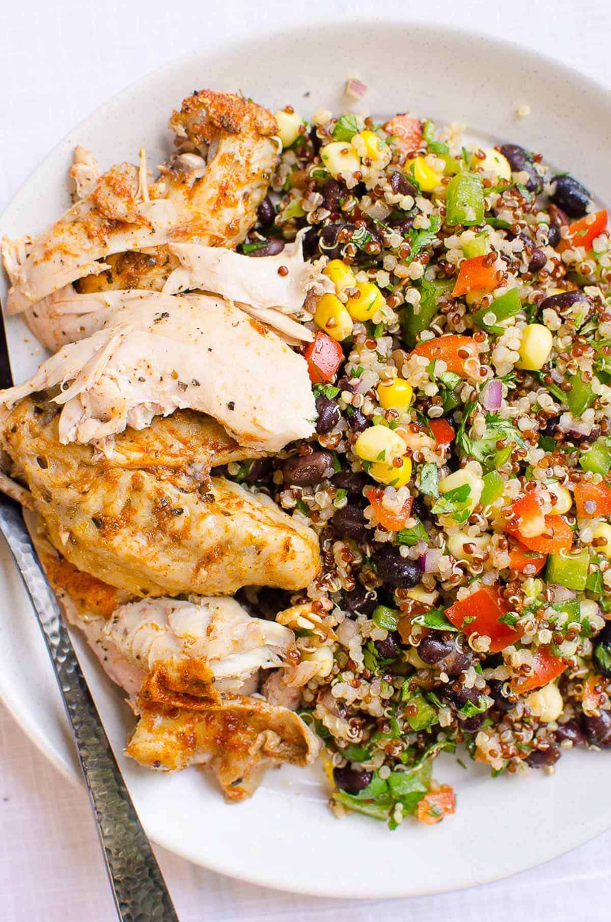 Quinoa salad served with chicken on a plate.