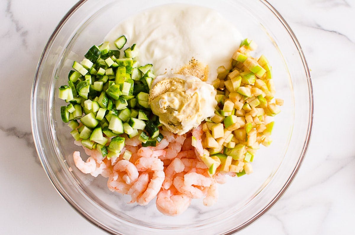 Diced green apple, cucumber, shrimp, Greek yogurt, mayo mustard and spices in bowl.