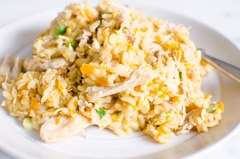 Instant pot chicken and rice garnished with parsley on a plate.