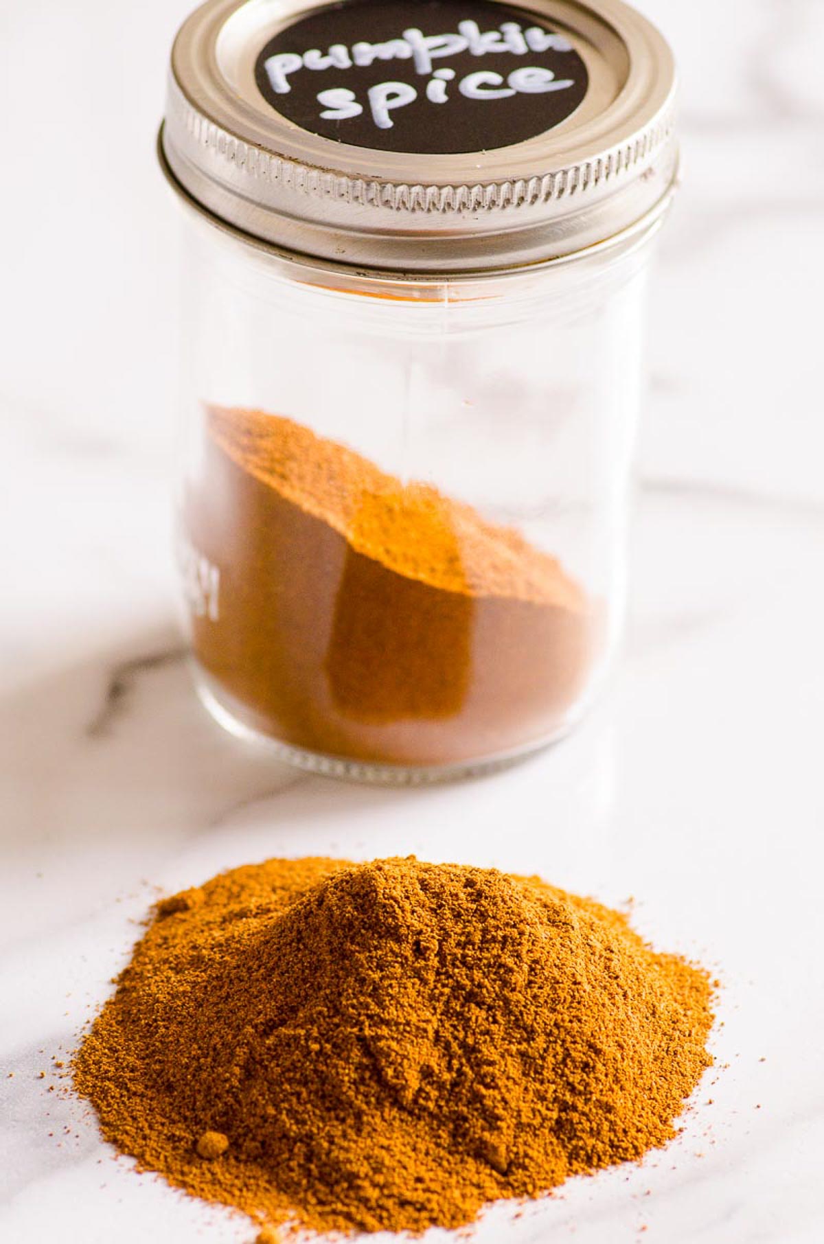 Pumpkin pie spice substitute on counter and in labeled jar.