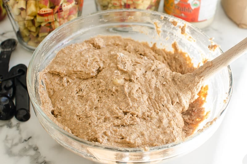 Flour mixed into quick bread batter in a glass bowl.