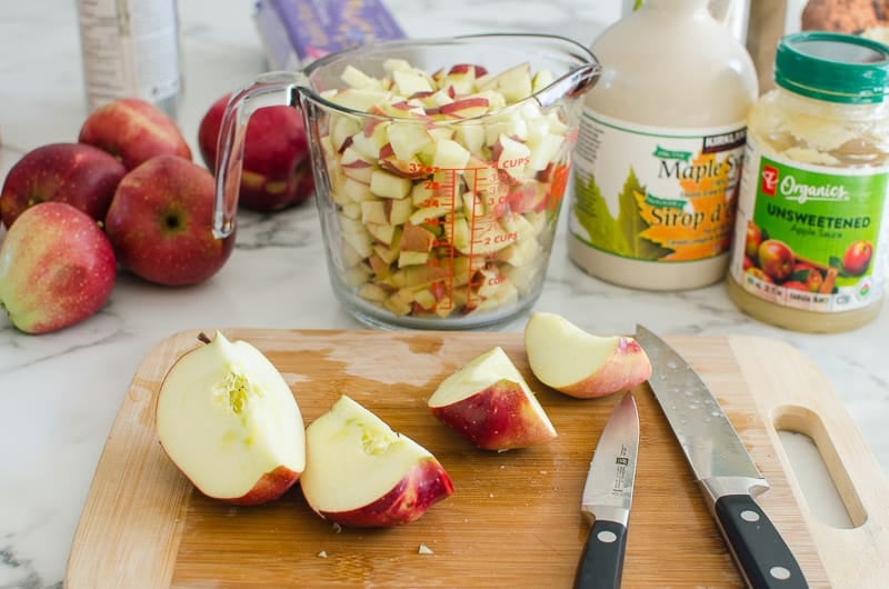 Chopped apples on cutting board and in measuring cup.