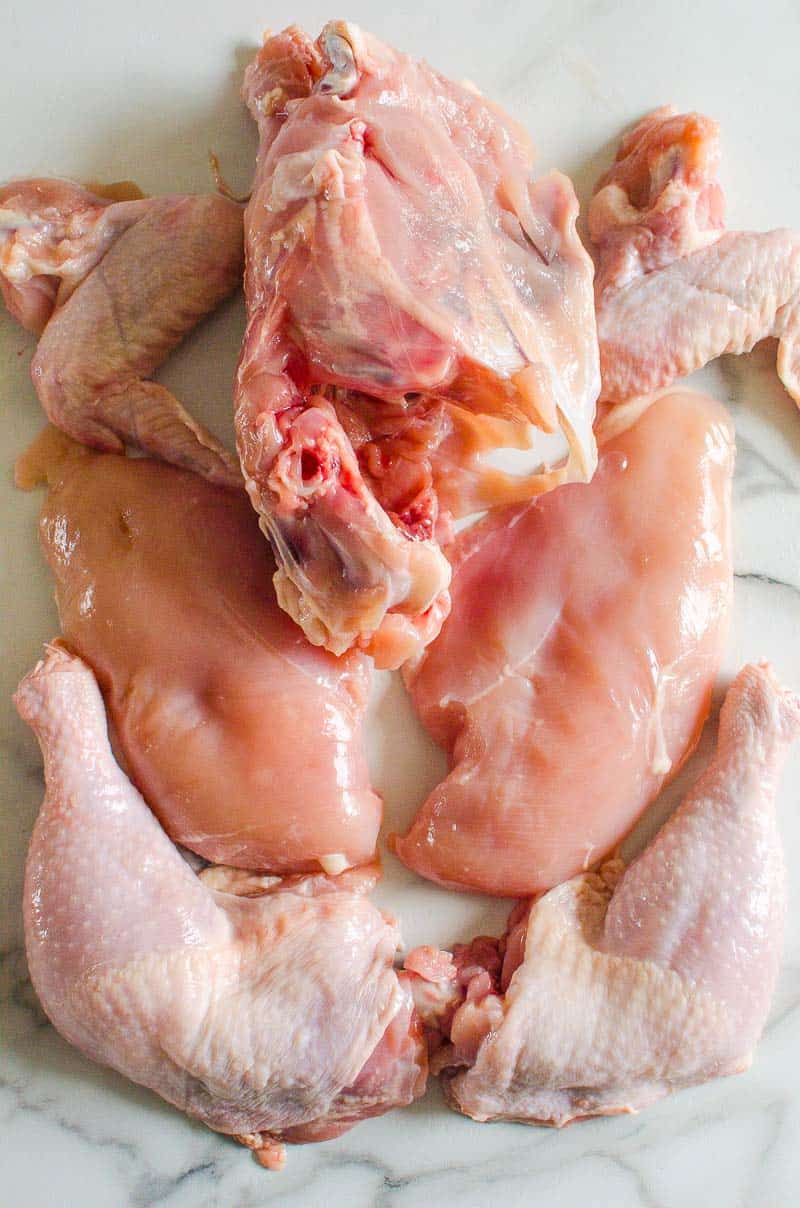 cut up whole chicken into pieces on a counter