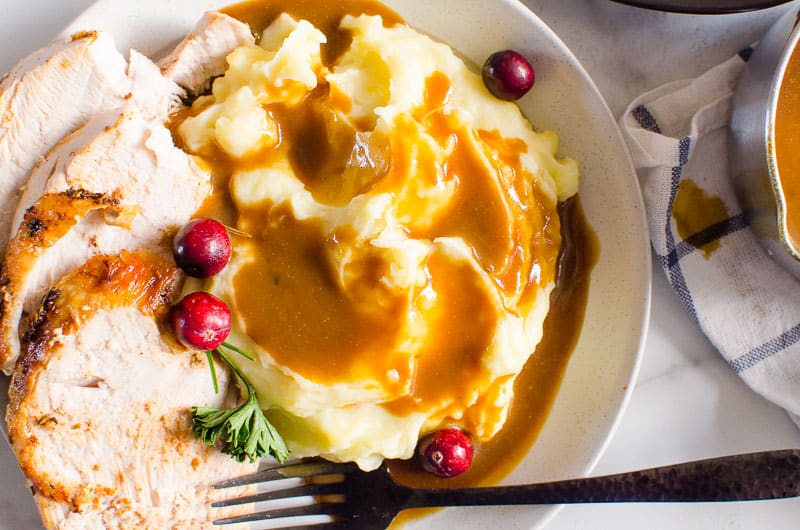 turkey breast with mashed potatoes and gravy on a plate