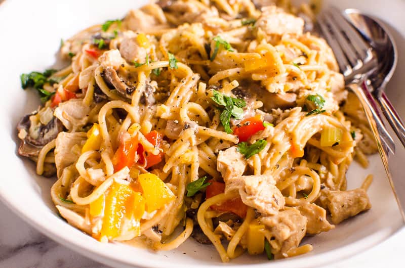 One Pot Turkey Tetrazzini in a white bowl with spoon and fork