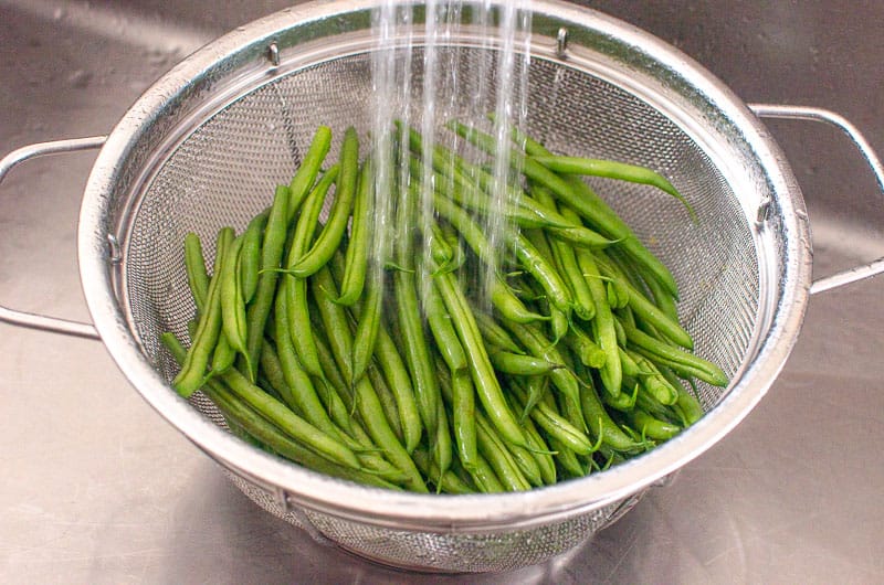 washing fresh green beans in colander