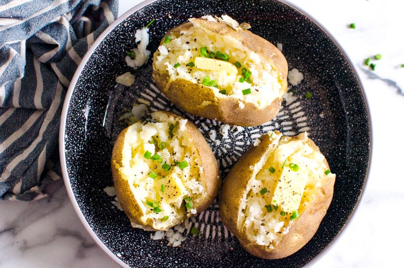 Instant Pot baked potatoes served on a plate garnished with green onions