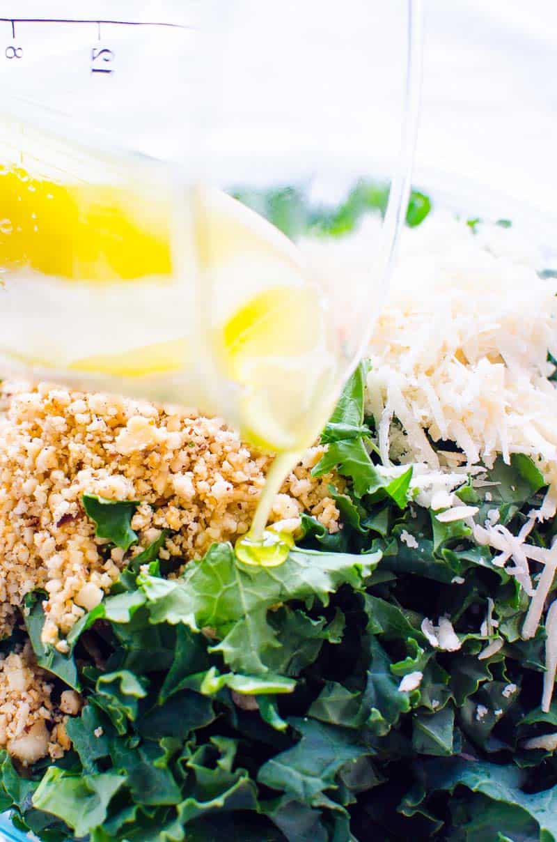 lemon dressing pouring over kale salad