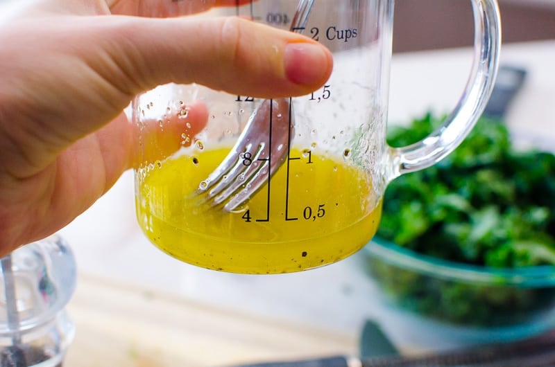 Lemon garlic dressing in measuring cup with fork.