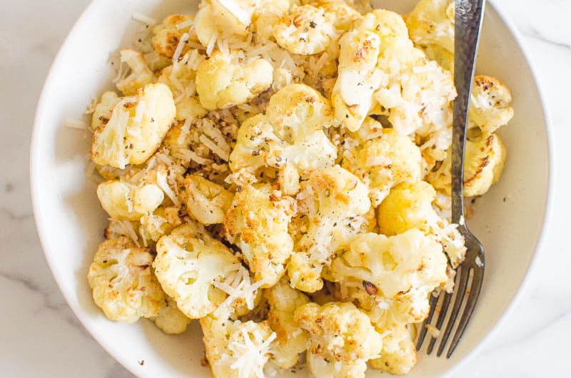 roasted cauliflower served in a white bowl with fork