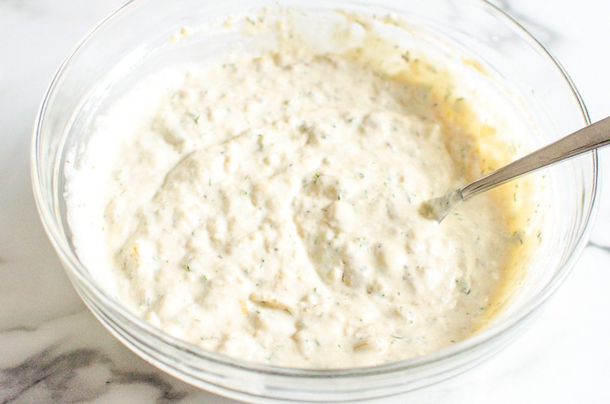 A bowl of healthy french onion dip with a spoon.