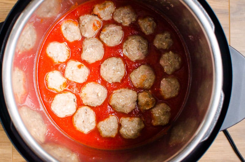 meatballs placed in the instant pot in sauce