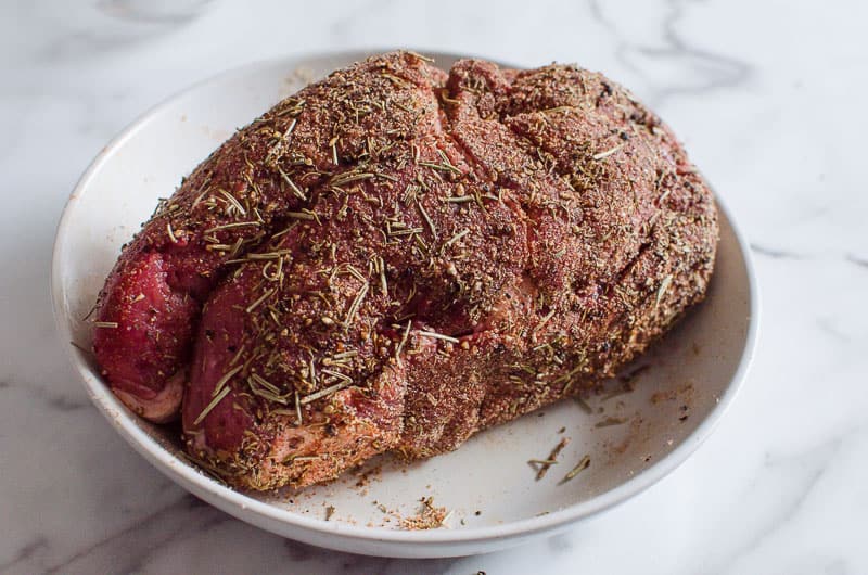 Dry rub on a beef roast on a plate.