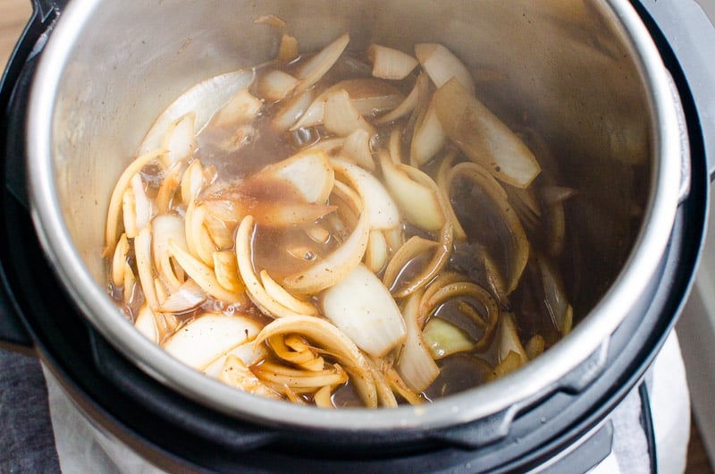 Sauteed sliced onions with broth, vinegar and wine in pressure cooker.