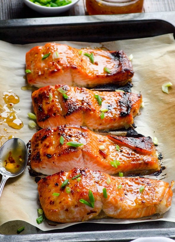 Broiled thai salmon fillets on baking sheet lined with parchment.