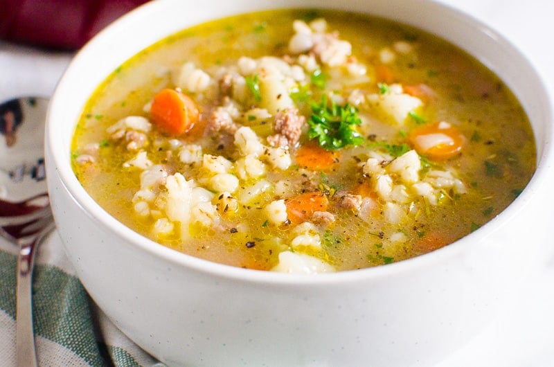 Beef Barley Soup in a bowl served garnished with parsley.