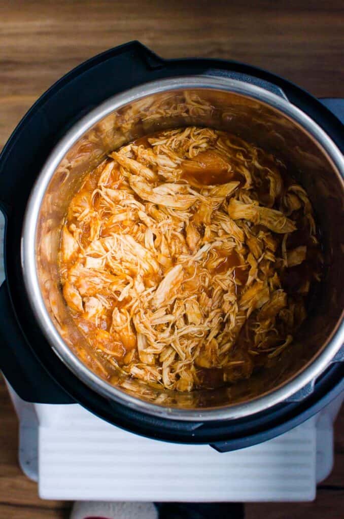 Instant Pot with BBQ chicken in pressure cooker pot.