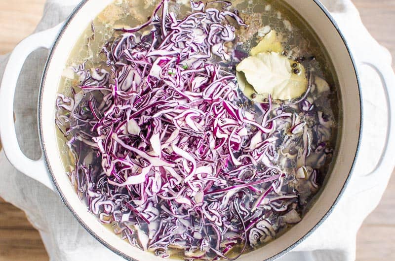 shredded cabbage in pot with broth