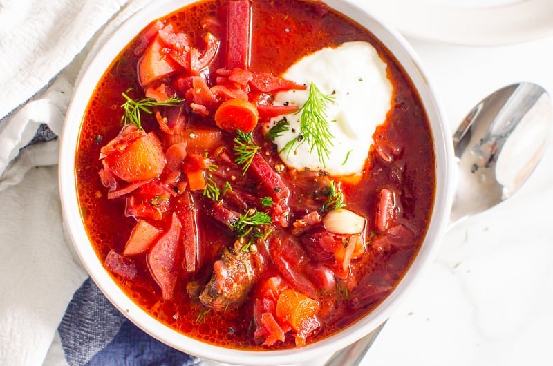 Ukrainian borscht served in a bowl with a dollop of sour cream and dill.