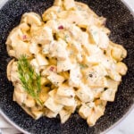 Healthy egg salad garnished with dill in black bowl.