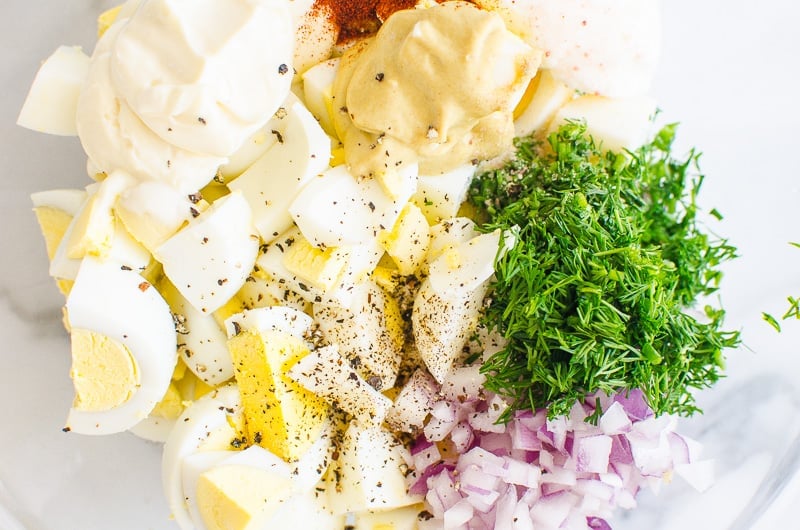Healthy Egg Salad ingredients include chopped eggs, red onion, dill, mustard, mayo, yogurt