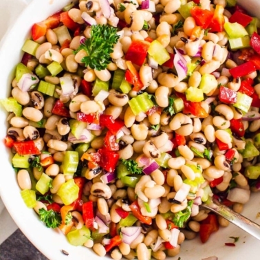 White bean salad in a bowl with a spoon.